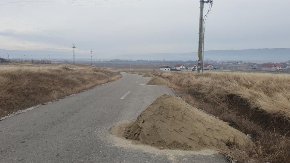 Dispar grămezile de nisip depozitate pe un drum din Gorj