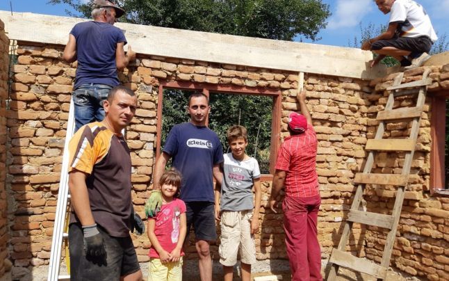 Voluntari care reconstruiesc o casă în Gorj, înjurați de localnici